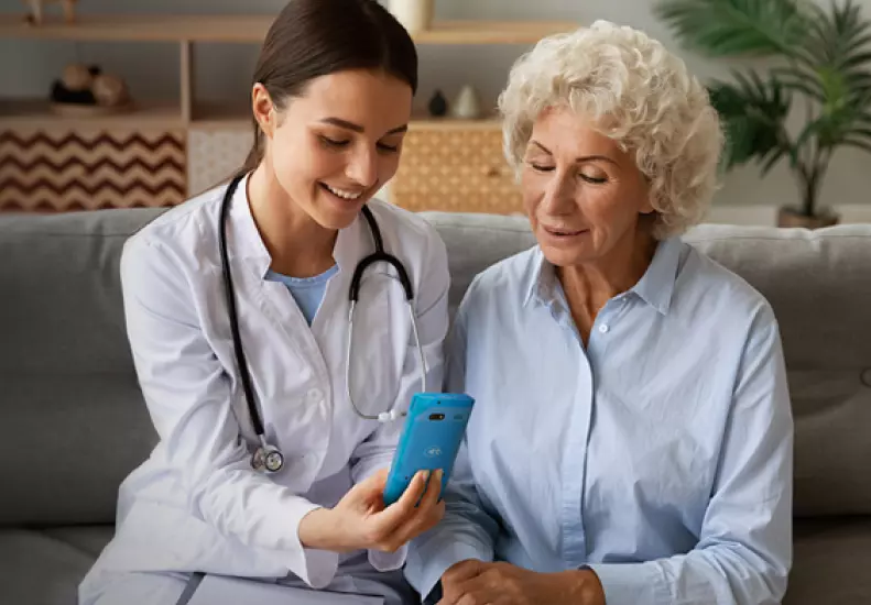 Médico realizando el cobro de sus servicios en el domicilio de la paciente con la terminal móvil